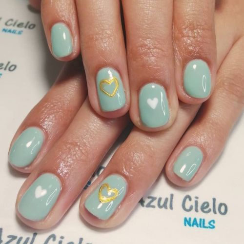 Uñas azul con corazones dorados