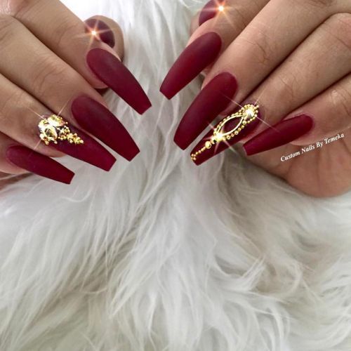 Uñas mate en color vino con dorado